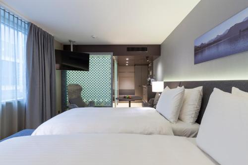 a hotel room with two beds and a window at Radisson Blu Hotel, Lucerne in Luzern