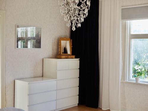 a bedroom with a white dresser and a chandelier at Orsastuguthyrning-Kyrkbyn in Orsa