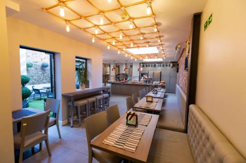a restaurant with tables and chairs and a kitchen at Comfotel PRPL in London