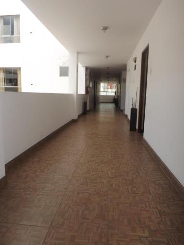 un pasillo vacío de un edificio de oficinas con suelo de ladrillo en Venecia Hotel Carrion, en Trujillo