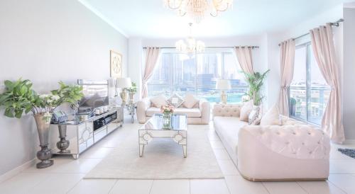 a living room with white furniture and a chandelier at Elite Royal Apartment - Full Burj Khalifa & Fountain view - Opal - 2 bedrooms plus 1 open bedroom without partition in Dubai
