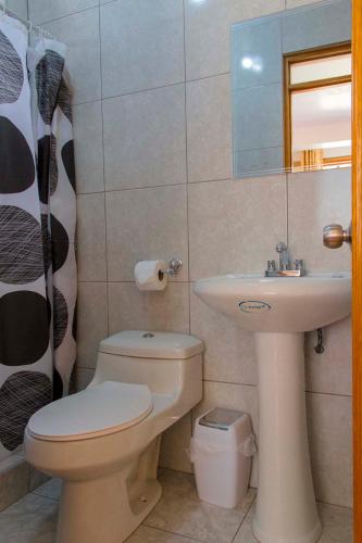 a bathroom with a white toilet and a sink at Tumy house B&B in Ollantaytambo