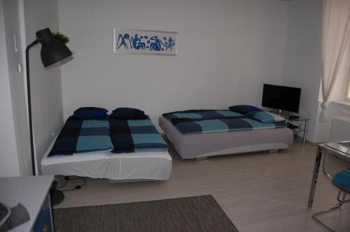 sypialnia z 2 łóżkami, biurkiem i lampką w obiekcie Apartman a Szentlélek u. -3ban w mieście Sopron