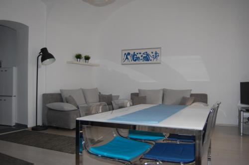 uma mesa num quarto com cadeiras e um sofá em Apartman a Szentlélek u. -3ban em Sopron