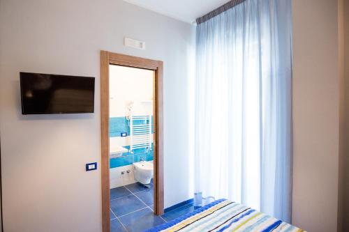1 dormitorio con cama y baño con espejo. en Residenza Sole Maiori en Maiori