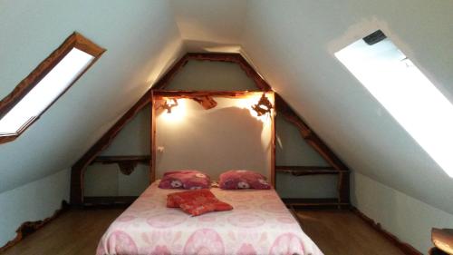 une chambre avec un lit dans un grenier dans l'établissement Maisonnette atypique au pied des monts d'Arree, à Commana