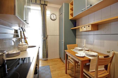 a kitchen with a table and a clock on the wall at Apartament Monte Mario in Rome
