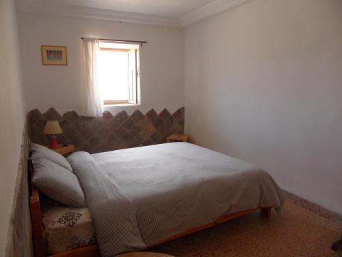 a bedroom with a bed and a window at Gite Tigmi Azrur in Tabant