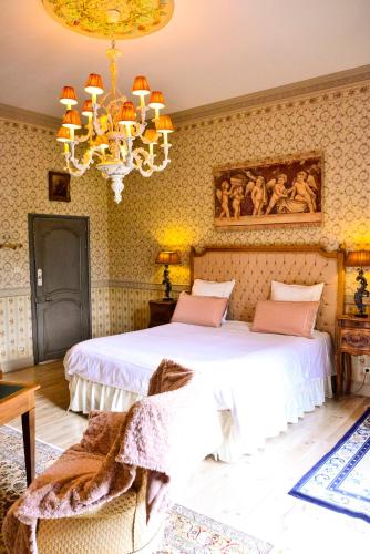a bedroom with two beds and a chandelier at Chateau d'Origny, Chambres d'hotes et Restaurant Gastronomique in Ouches