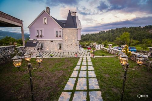 a house with lights on the lawn in front of it at Hotel Restaurant Vila Ime Voskopoje in Voskopojë