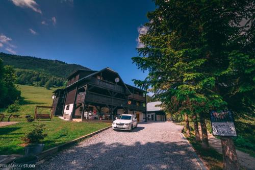 a white car parked in front of a building at Penzion Muran in Terchová
