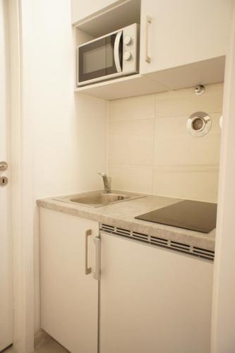 a white kitchen with a sink and a microwave at Ferienwohnung Lörrach in Lörrach