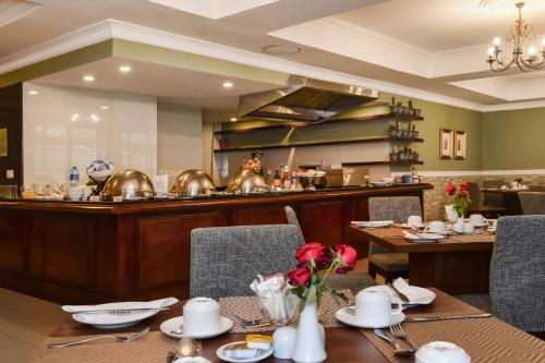 a dining room with a table and a kitchen at BON Hotel Abuja in Abuja