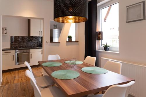 uma cozinha e sala de jantar com uma mesa de madeira e cadeiras em Tom's Ferienappartements Appartment 2 em Tabarz