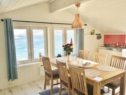 cocina y comedor con mesa y sillas en Cape Marina Penthouse en Skarsvåg