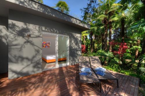 a house with two benches on a patio at Du Lac Et Du Parc Grand Resort in Riva del Garda