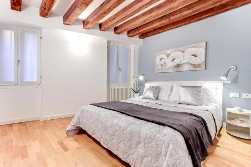 een witte slaapkamer met een groot bed. bij San Marco - Campo Manin in Venetië
