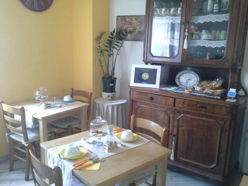 a dining room with two tables and a china cabinet at B&B Ciccilia in Bentivoglio