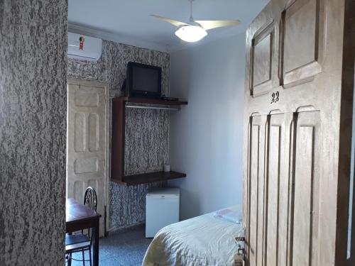 a bedroom with a bed and a tv on a wall at Araca Hotel in Araçatuba