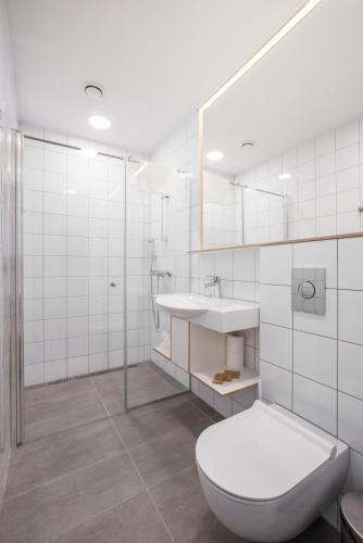 a white bathroom with a toilet and a sink at #draugunamai in Druskininkai