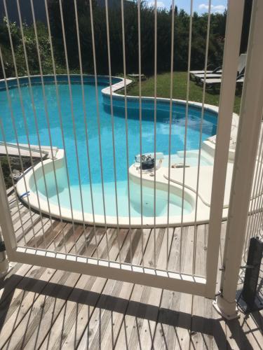 uma vista a partir da varanda de uma piscina em Chambre dans une villa em Beaupuy