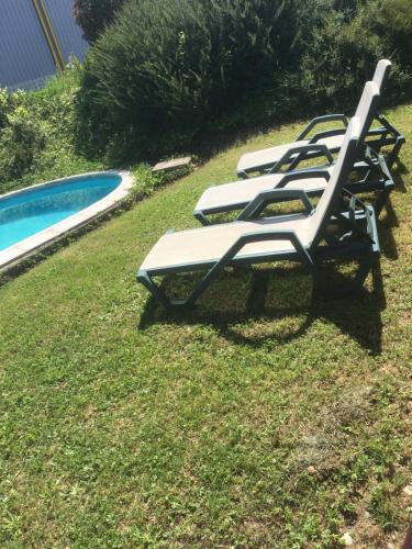 - une rangée de chaises longues à côté de la piscine dans l'établissement Chambre dans une villa, à Beaupuy