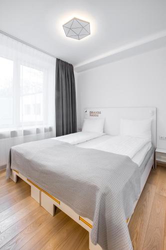 a bedroom with a large bed with white sheets at #draugunamai in Druskininkai