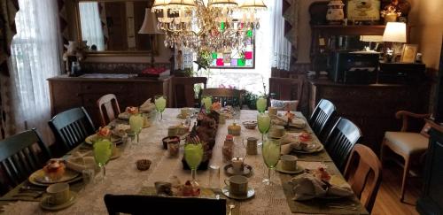uma sala de jantar com uma mesa longa com comida em Rose & Thistle Bed & Breakfast em Cooperstown