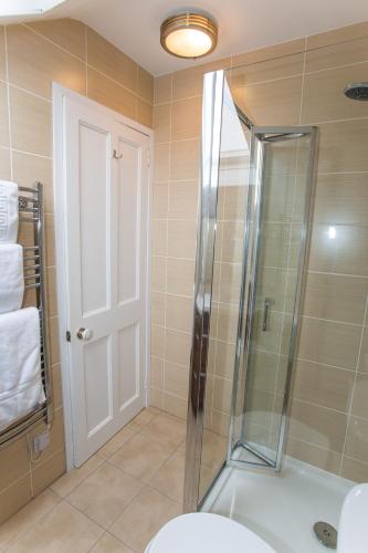 a bathroom with a shower with a glass door at Butt Lodge in Lochranza