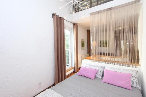 a bedroom with a bed with pink pillows and a window at Apartment Marjanovic in Rovinj