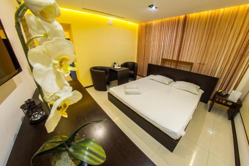 una habitación de hotel con una cama y una mesa con flores en Spa-отель en Járkov