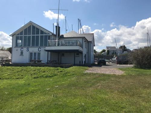 a large white building with a balcony on top of a field at Ballymacdoe Cottage Cushendall in Cushendall