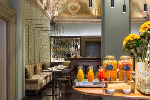 a restaurant with a bar with orange vases on a table at Grand Hotel Cavour in Florence
