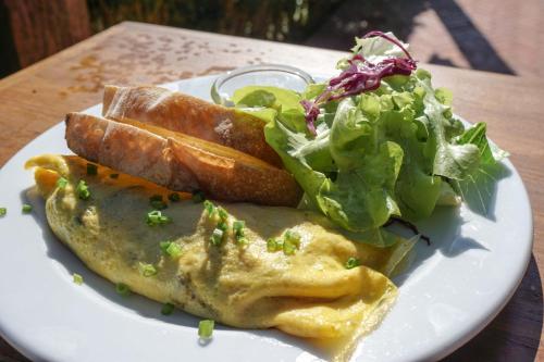 einen Teller Essen mit Omelett und Salat in der Unterkunft Reverie Siam in Pai