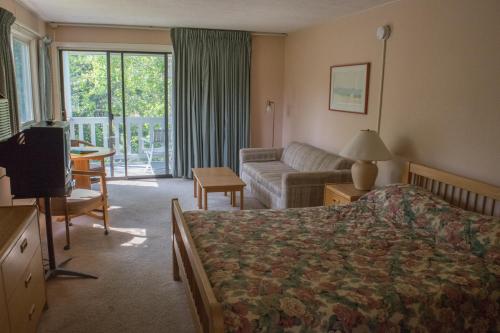 Habitación de hotel con cama y sofá en The Wayside Inn, en Bethlehem