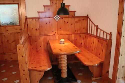 a wooden table and two benches in a room at Pension Kärnten in Seeboden