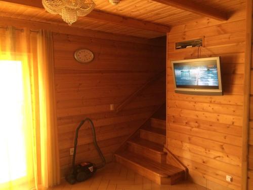 ゼリョンナヤ・ポリャナにあるБунгало НП "Горное" на Банномの木製の壁の客室で、テレビと階段が備わります。