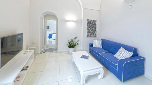 a living room with a blue couch and a table at Exclusive Home Ischia in Ischia