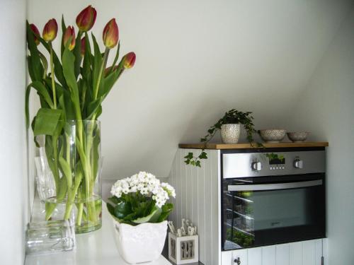 a vase of flowers sitting on top of a microwave at De Moeraseik in Zele