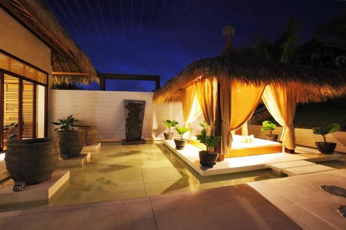 a patio with a large umbrella and potted plants at The Cliff Resort & Residences in Mui Ne