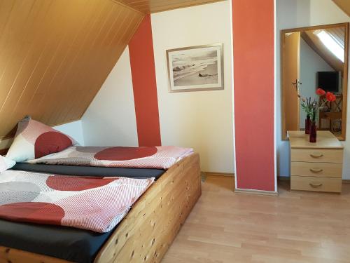 1 dormitorio con 2 camas y espejo en Kleines Häuschen am Deich, vor den Toren von Sylt, en Emmelsbüll-Horsbüll