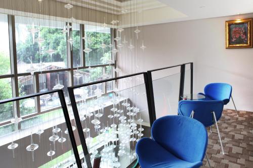 two blue chairs in front of a window with chandeliers at Micasa Hotel in Taichung
