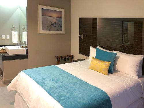 a bedroom with a large bed and a sink at KABAH Cancun Hotel Boutique in Cancún
