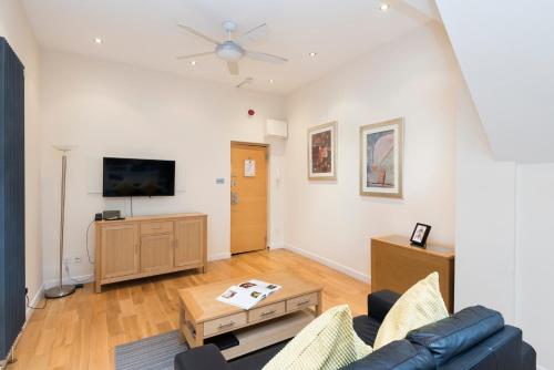a living room with a couch and a tv at St Paul's by Excel Apartments in London