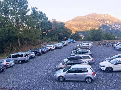 Une rangée de voitures garées sur un parking dans l'établissement Hôtel Angelic, à Lourdes