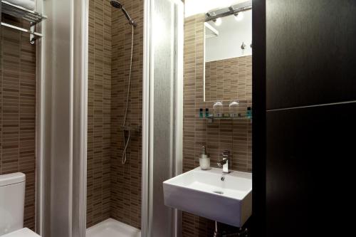 uma casa de banho com um lavatório, um chuveiro e um WC. em THC Latina Hostel em Madri