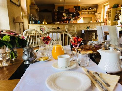a dining room table with a white table cloth and orange juice at Chateau d'Origny, Chambres d'hotes et Restaurant Gastronomique in Ouches