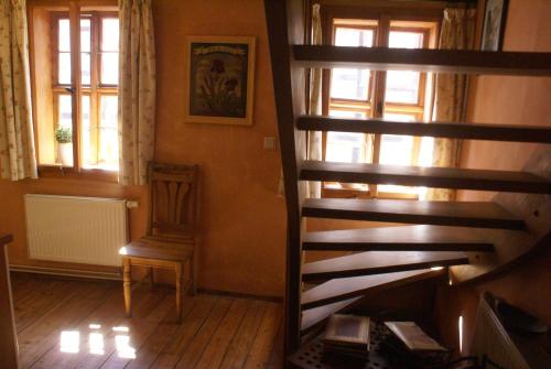 a stairway in a room with a chair and windows at Ferienwohnung im Schuhhof in Quedlinburg