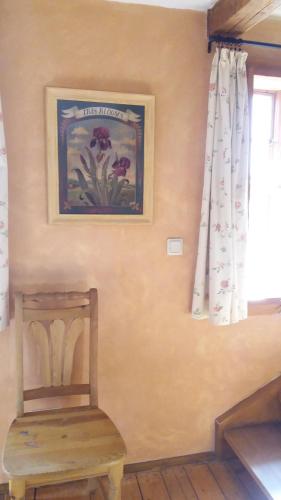 a chair in a room with a picture on the wall at Ferienwohnung im Schuhhof in Quedlinburg