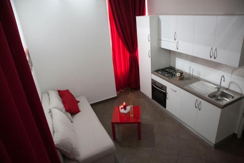 カターニアにあるDomus Claudiaeのリビングルーム(白いソファ、赤いテーブル付)